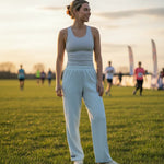 Woman standing on a grassy field with people in the background