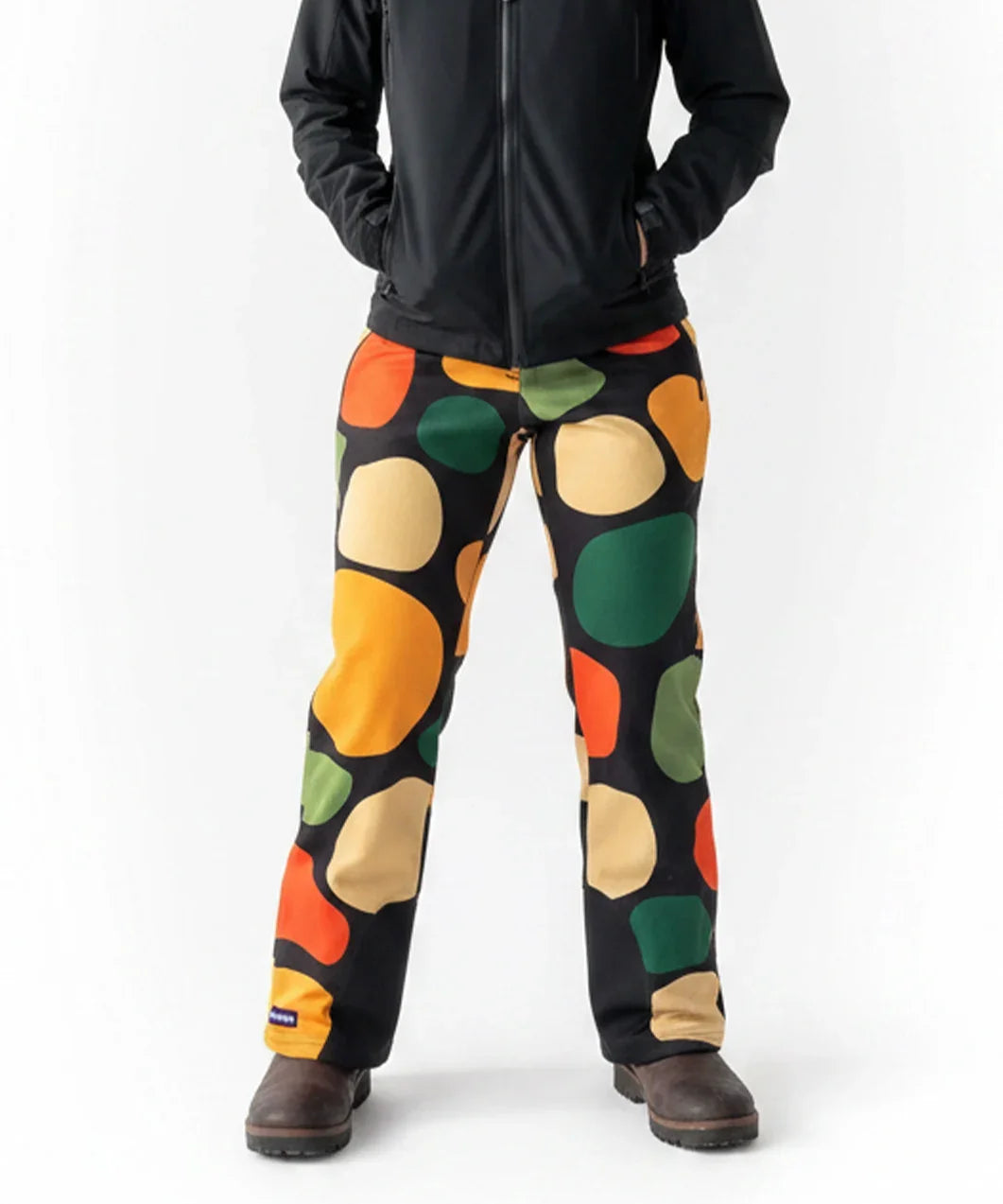 Person wearing Loones Rubble black trousers with colorful abstract pattern on a white background
