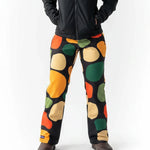 Person wearing Loones Rubble black trousers with colorful abstract pattern on a white background
